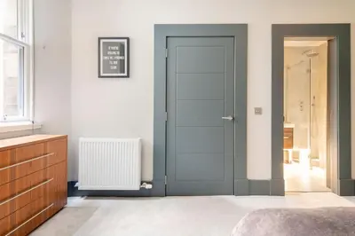 a bedroom with a door and a radiator at Immaculate 3 Bed Apartment with Private Entrance in Inverleith in Edinburgh