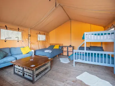 a room with a couch and a table in a tent at Cobleland Campsite in Gartmore