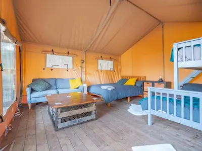 a living room in a tent with couches and a table at Cobleland Campsite in Gartmore