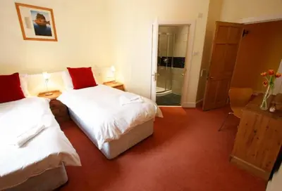 a bedroom with two beds and a walk in shower at Edlets - Frederick Street Apartment in Edinburgh