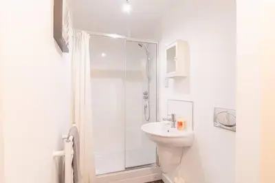 a white bathroom with a shower and a sink at Luxury Riverview City Centre Apartment 2 in Glasgow