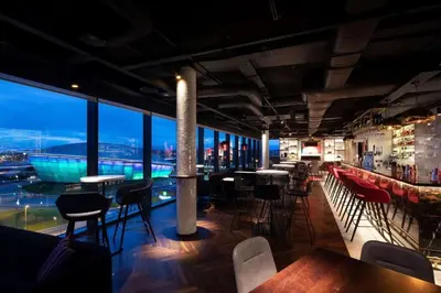 a bar with chairs and tables and a view of the city at Glasgow, Finnieston Luxury 2 Bed with parking, e-check in, hi-fi in Glasgow