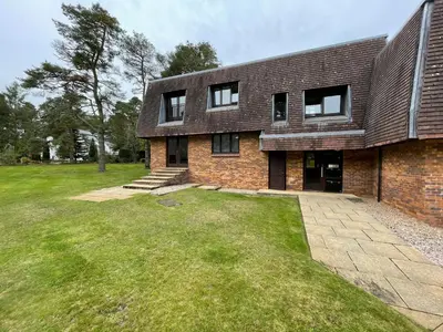 a brick house with a grass yard in front of it at Gleneagles Rental in Auchterarder