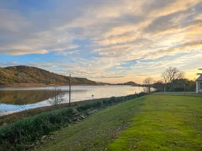 a grassy field next to a body of water at Tulamain in Ardfern
