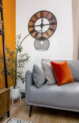 a living room with a couch and a clock on the wall at The Stylish 3-Bedroom Maisonette Retreat in Stirling