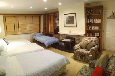 a bedroom with a bed and a couch and a fireplace at Stunning 7BR GardenVilla - Glasgow & Loch Lomond - Sleeps25 - PleasantHillScotland in Milngavie