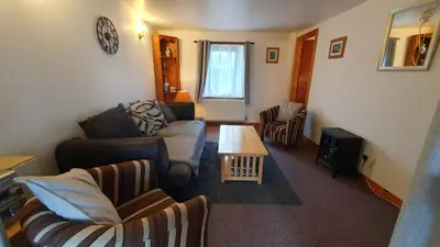 a living room with a couch and a table at Rhumhor in Bunessan