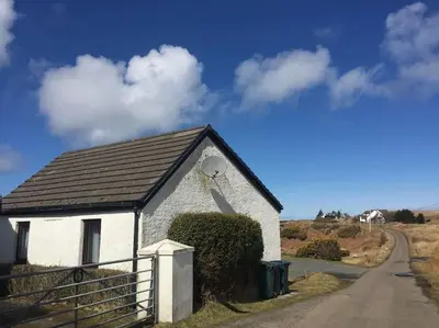 a small white building on the side of a road at Rhumhor in Bunessan