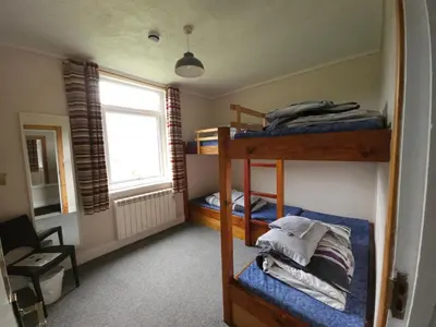 a room with three bunk beds and a window at West Highland Lodge in Kinlochleven
