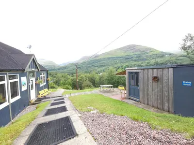 a house and a shed with a picnic table at West Highland Lodge in Kinlochleven