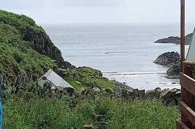a house on the side of a hill near the ocean at Ardchiavaig Cabin in Uisken