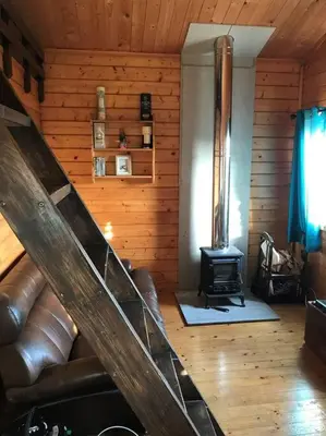 a living room with a couch and a stove at Ardchiavaig Cabin in Uisken
