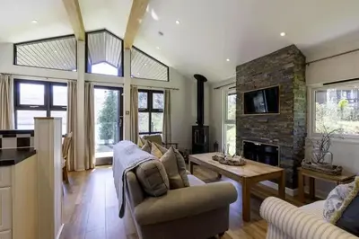 a living room with a couch and a fireplace at Sixpenny Bay in Morenish