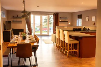 a kitchen and dining room with a table and chairs at Cairn Cottage in Onich