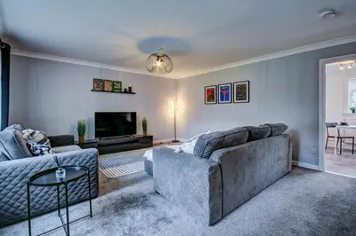 a living room with a couch and a tv at Ravenscroft - Coorie Doon in Irvine