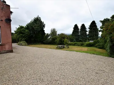 a picnic table in a park next to a building at 5 Bed in Brodick CA016 in Brodick