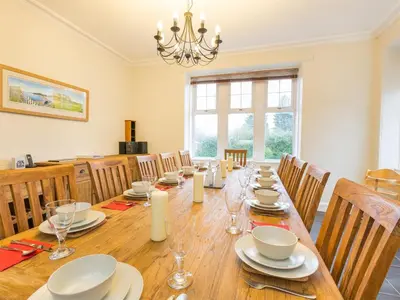 a dining room with a long table and chairs at 5 Bed in Brodick CA016 in Brodick