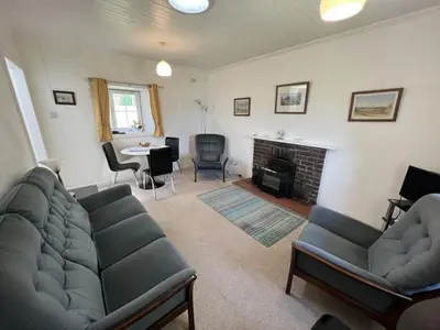 a living room with a couch and a fireplace at Ellary Cottage in Stonefield