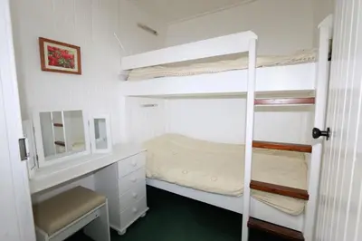 a bedroom with two bunk beds and a mirror at Ellary Cottage in Stonefield