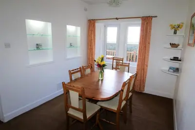a dining room with a table and chairs and a window at The Lodge in Lochgilphead