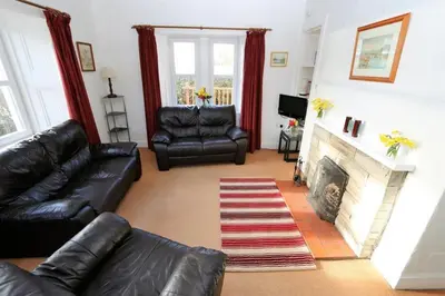 a living room with leather furniture and a fireplace at The Lodge in Lochgilphead