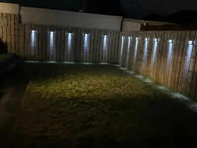 a backyard at night with a wooden fence at Tigh Lochlainn in Prestwick