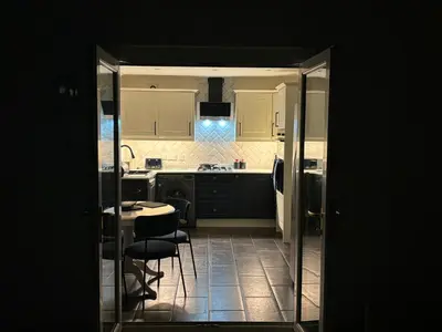 a kitchen with black cabinets and a table and chairs at Tigh Lochlainn in Prestwick