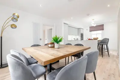 a dining room with a wooden table and chairs at Stunning Dalchenna w/hot tub & huge garden in Stirling