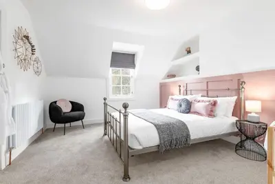 a bedroom with a bed and a chair at Stunning Dalchenna w/hot tub & huge garden in Stirling