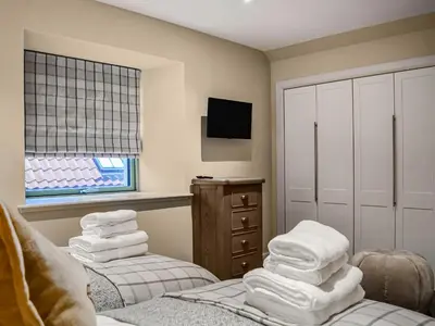 a room with towels stacked on top of a bed at The Old Mill in Linlithgow