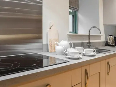 a kitchen counter with cups and saucers on it at The Old Mill in Linlithgow