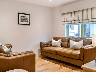 a living room with a brown leather couch at Pride Of Erin - Uk45929 in Linlithgow