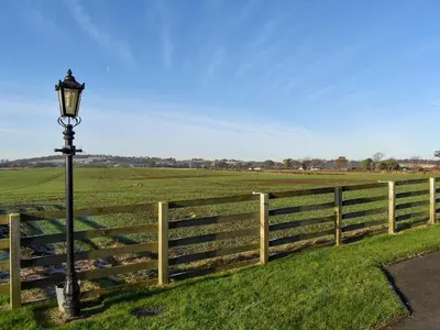 a light pole next to a fence with a field at Pride Of Erin - Uk45929 in Linlithgow