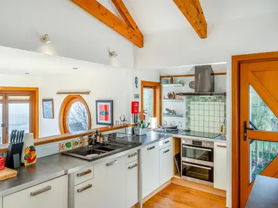 a kitchen with white cabinets and a counter top at Shore House in Kilcreggan