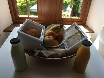 a bowl of fruit and two bottles of juice on a table at Alderdale B&B in Luss