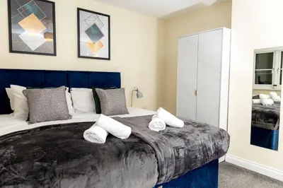 a bedroom with a large bed with pillows on it at Livingston North Station Apartments in Livingston