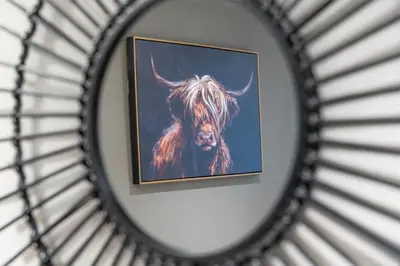 a picture of a bull in a mirror at Broom Cottage in Lanark