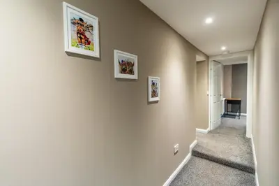 a hallway with three pictures on the wall at Broom Cottage in Lanark