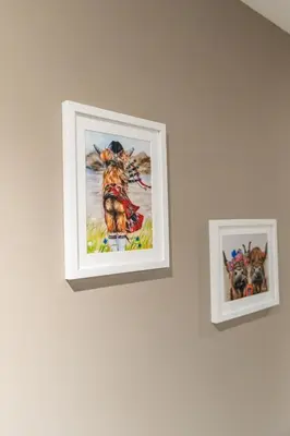 two framed pictures of a dog on a wall at Broom Cottage in Lanark