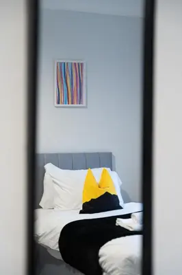 a mirror reflection of a bed in a bedroom at Kirkview Apartment in Kirk of Shotts