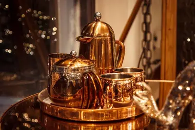 a gold tea kettle and cups on a table at Cameron North Lodge in Alexandria