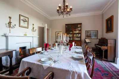 a dining room with a table and a piano at Tarbert Country Manor in Tarbert
