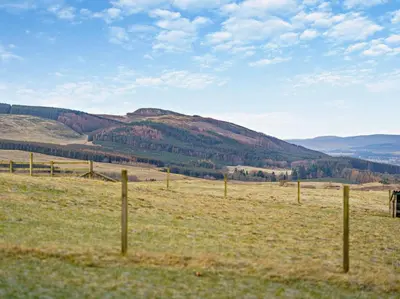 a fence in a field with mountains in the background at 1 Bed in Dunning oc-ca333 in Dunning