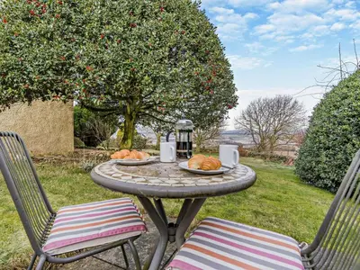 a table with a plate of food and two chairs at 1 Bed in Dunning oc-ca333 in Dunning