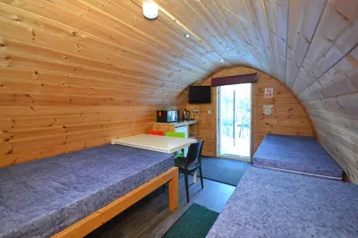 a room with two beds in a log cabin at Blackwater Glamping Pods in Kinlochleven