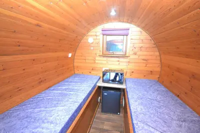 a room with two beds in a wooden cabin at Blackwater Glamping Pods in Kinlochleven