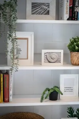 a shelf with two pictures and a plant on it at Linburn Cottage Dunfermline near Edinburgh in Dunfermline
