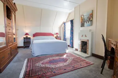 a bedroom with a bed and a fireplace at Ardnadrochet Cottage in Lochdon