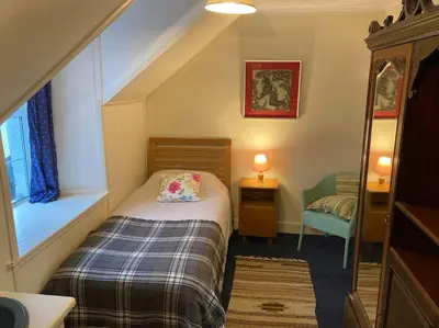 a small bedroom with a bed and a window at Ardnadrochet Cottage in Lochdon