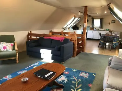 a living room with a blue couch and a table at Stable Cottage, Ardnadrochet in Lochdon